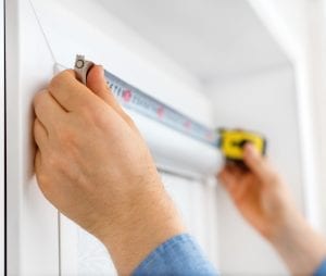 Man installing cassette roller blinds on windows