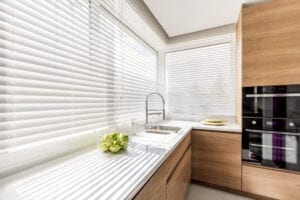 White horizontal blinds in modern kitchen. 